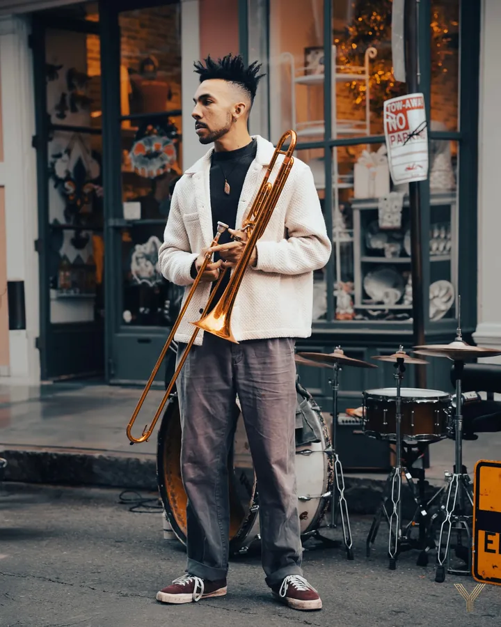 Street musician with a trombone outside a cafe